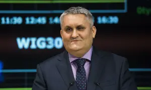 Mężczyzna w garniturze i krawacie przed ekranem z napisem WIG30.