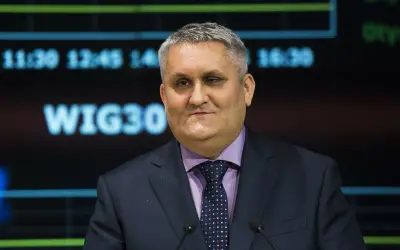 Mężczyzna w garniturze i krawacie przed ekranem z napisem WIG30.