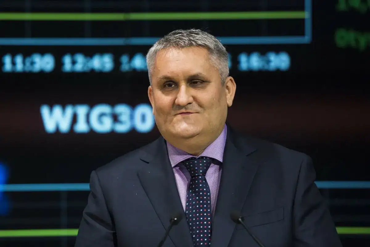 Mężczyzna w garniturze i krawacie przed ekranem z napisem WIG30.